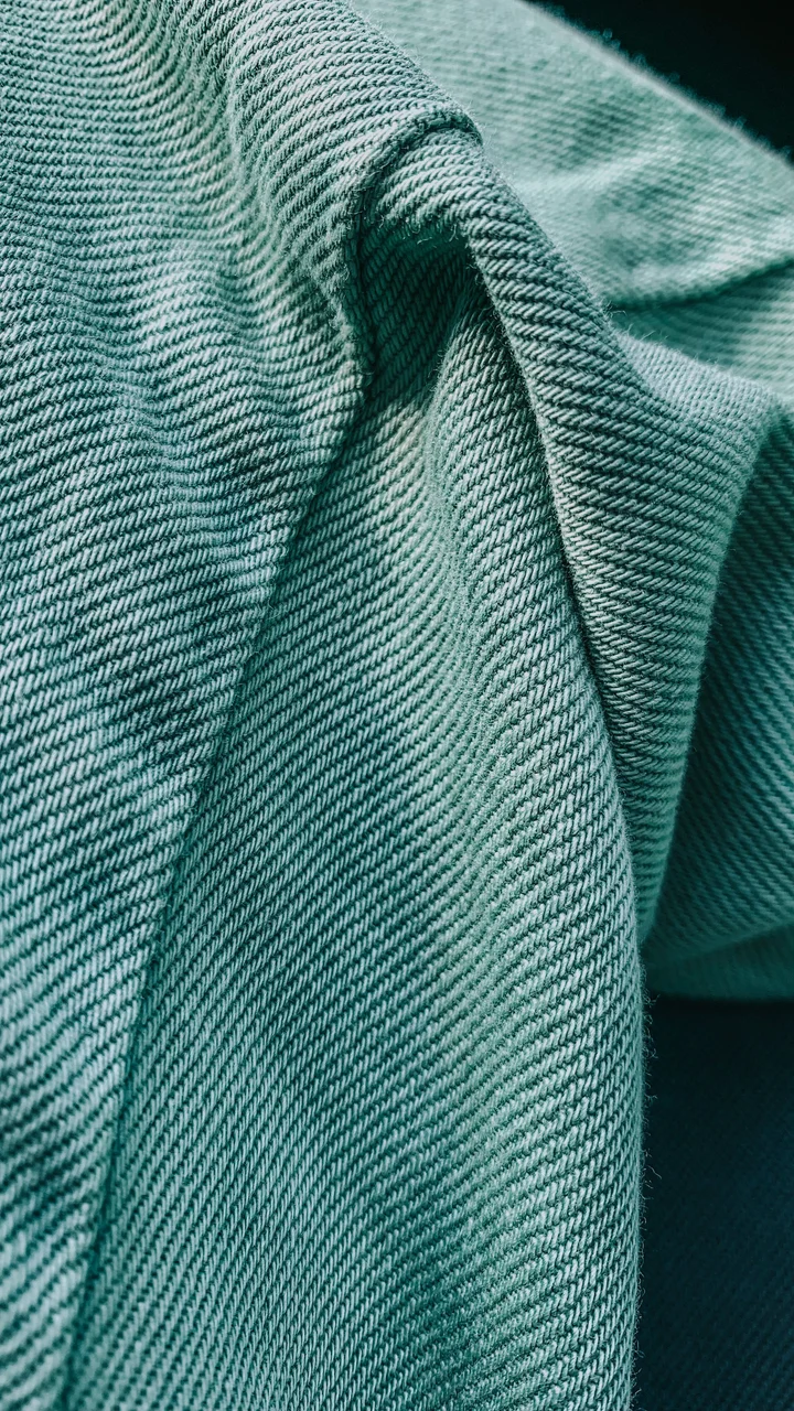 Close-up of soft green woven twill fabric lying in folds
